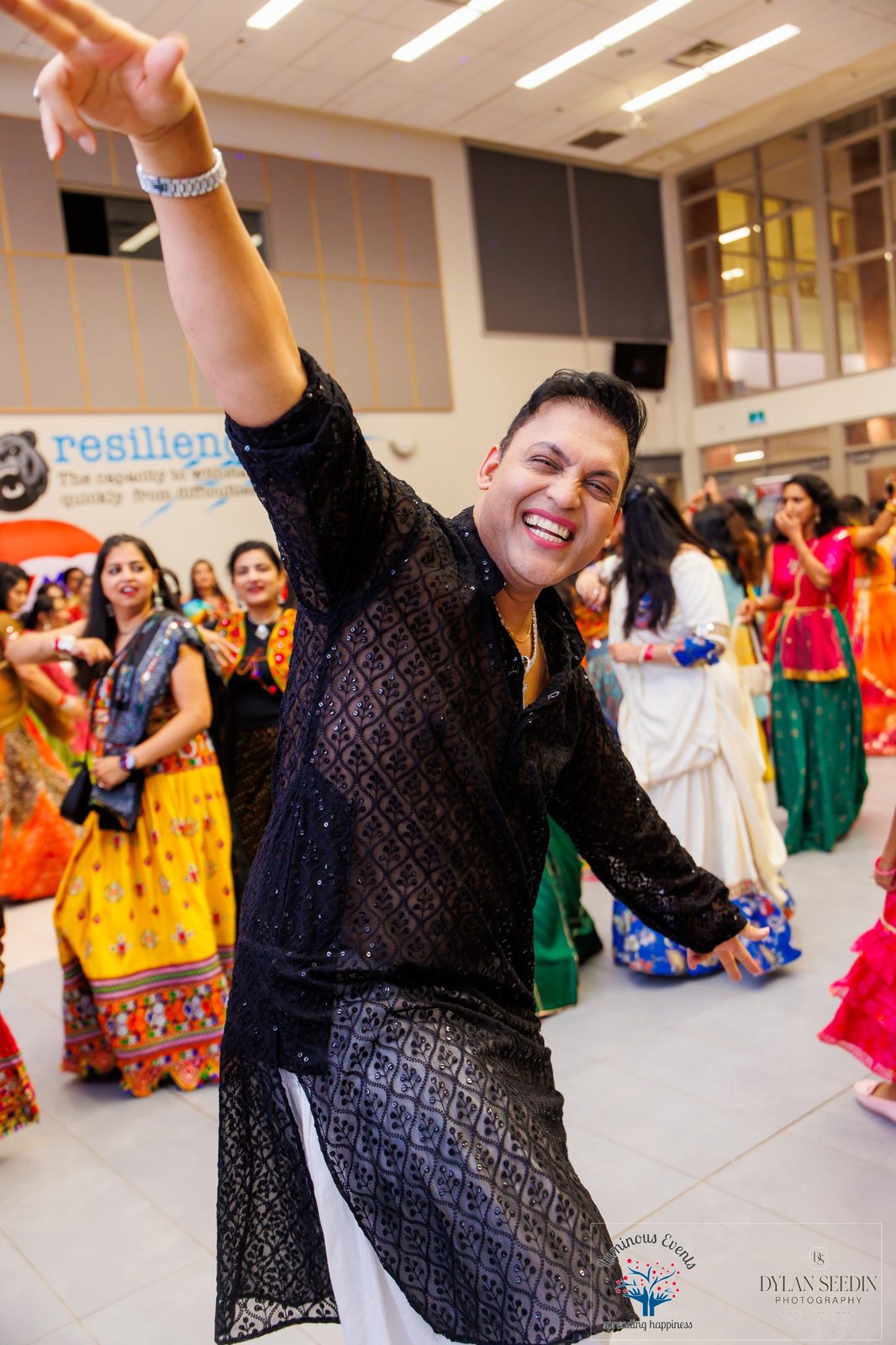 Guest in a black sequined kurta dancing with a big smile