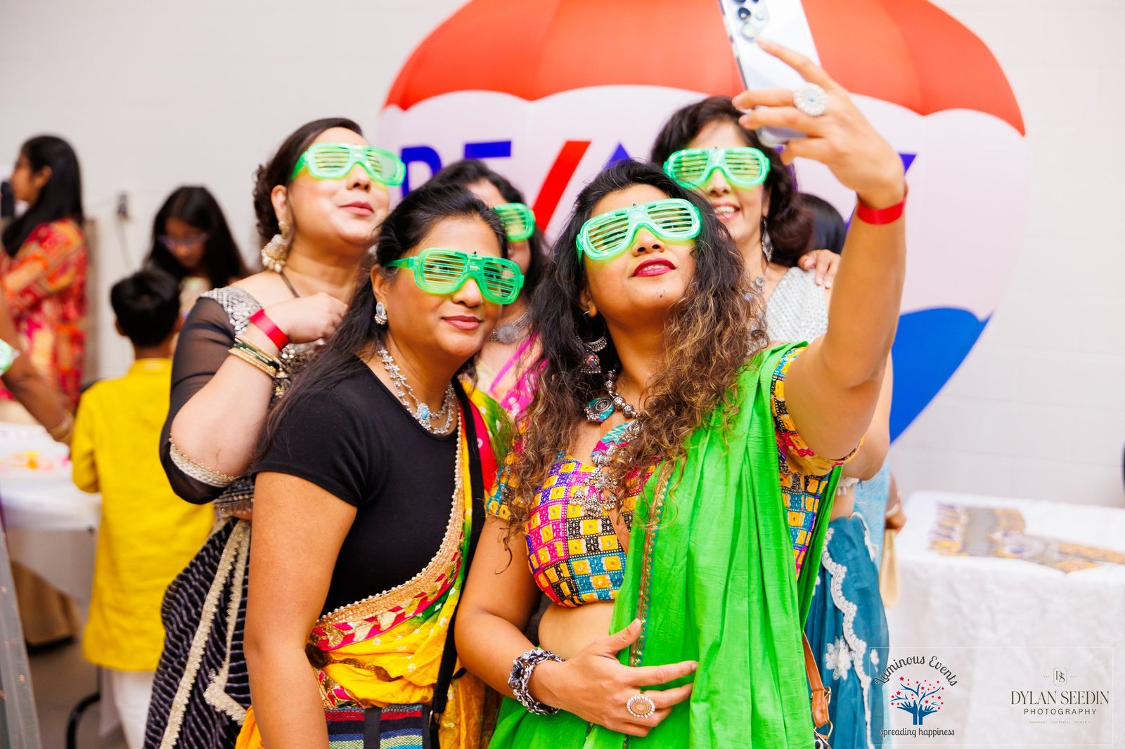 Friends in glowing green glasses taking a selfie