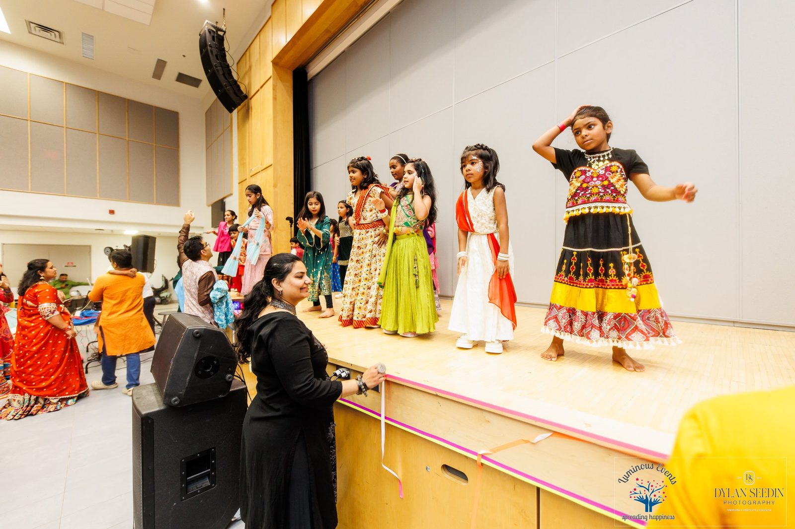 Kids in festive outfits dancing on stage