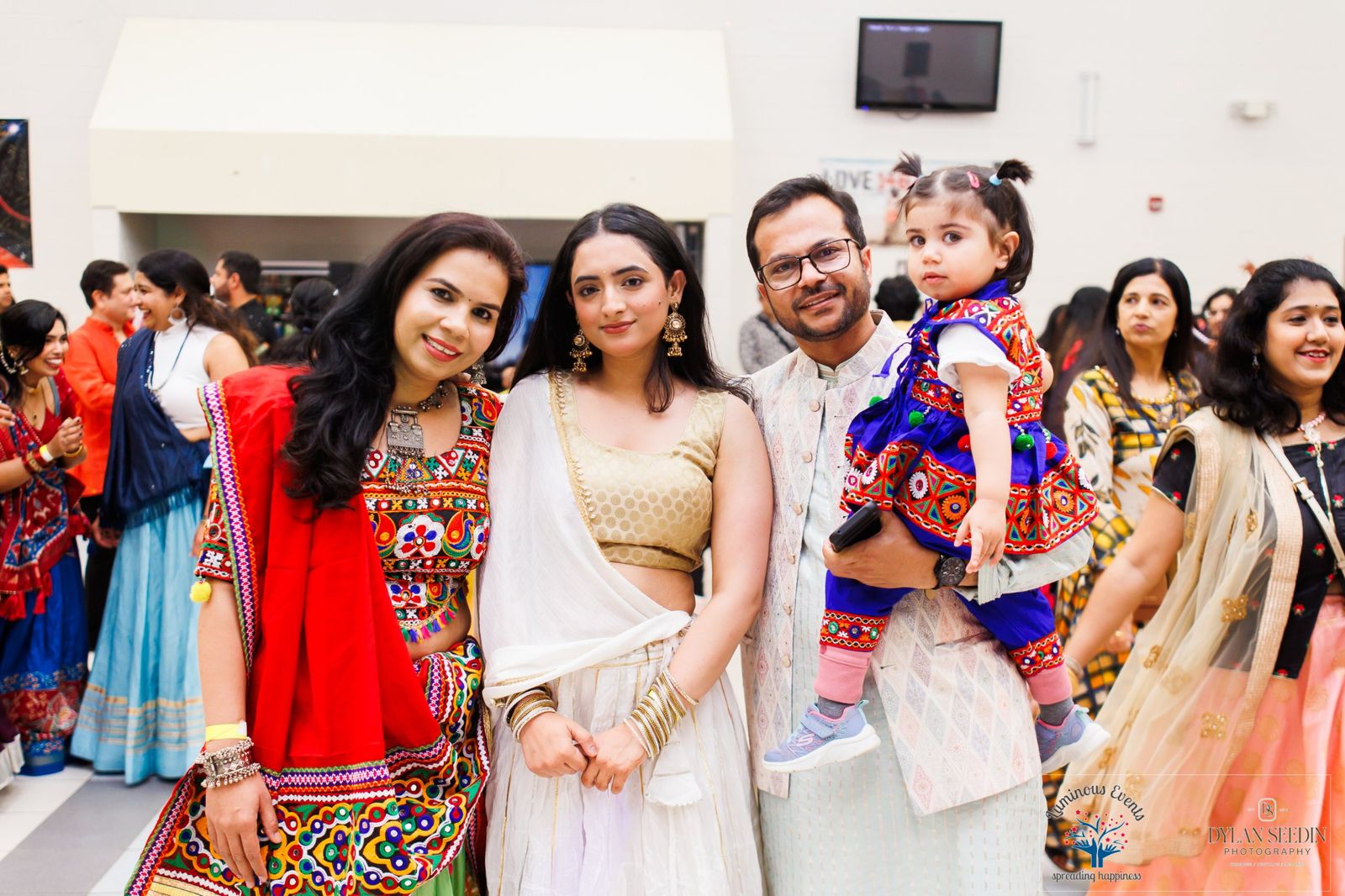 A young family with a toddler in a traditional outfit