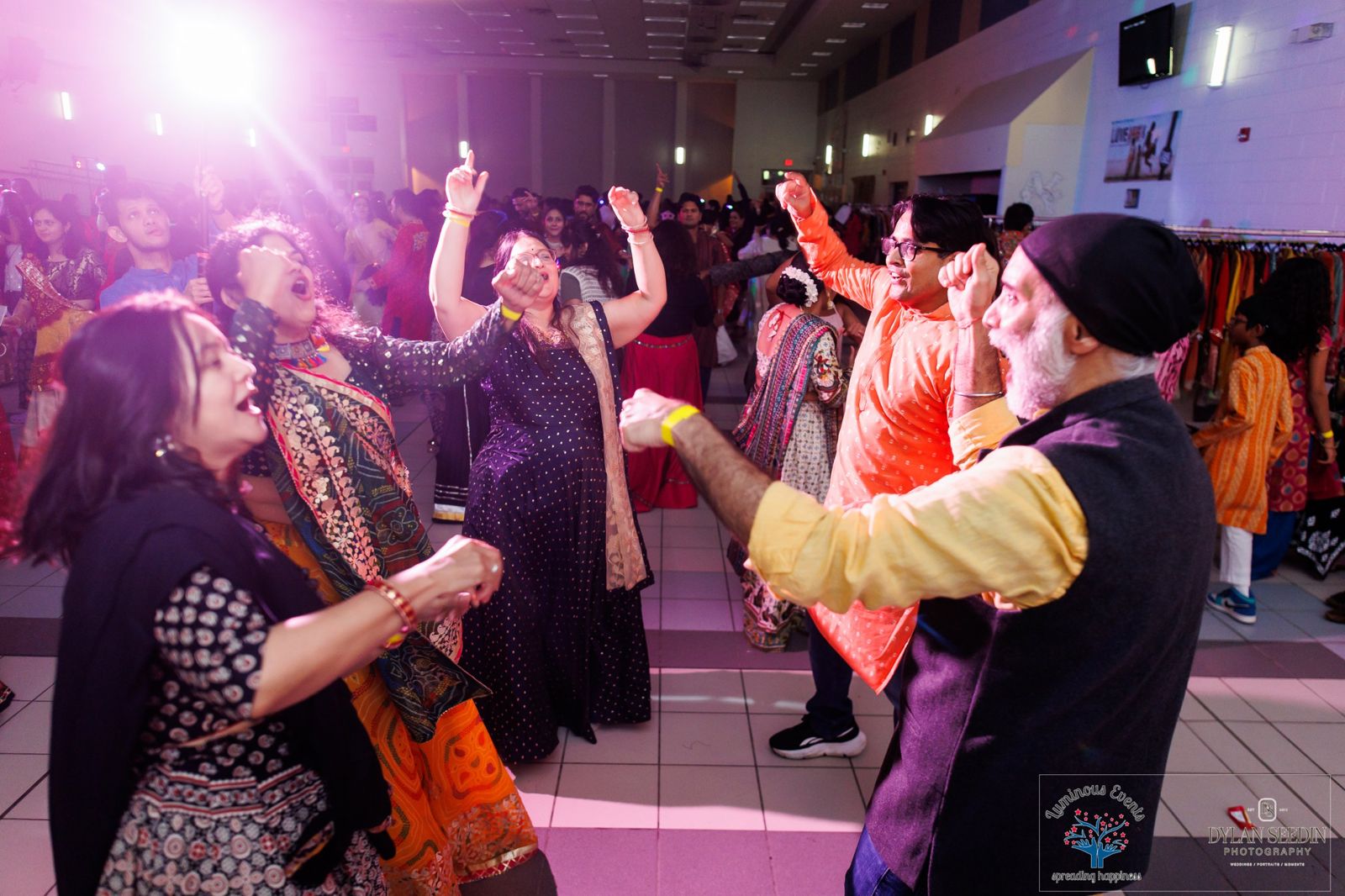 Dancers of different generations singing and dancing with raised fists under glowing lights