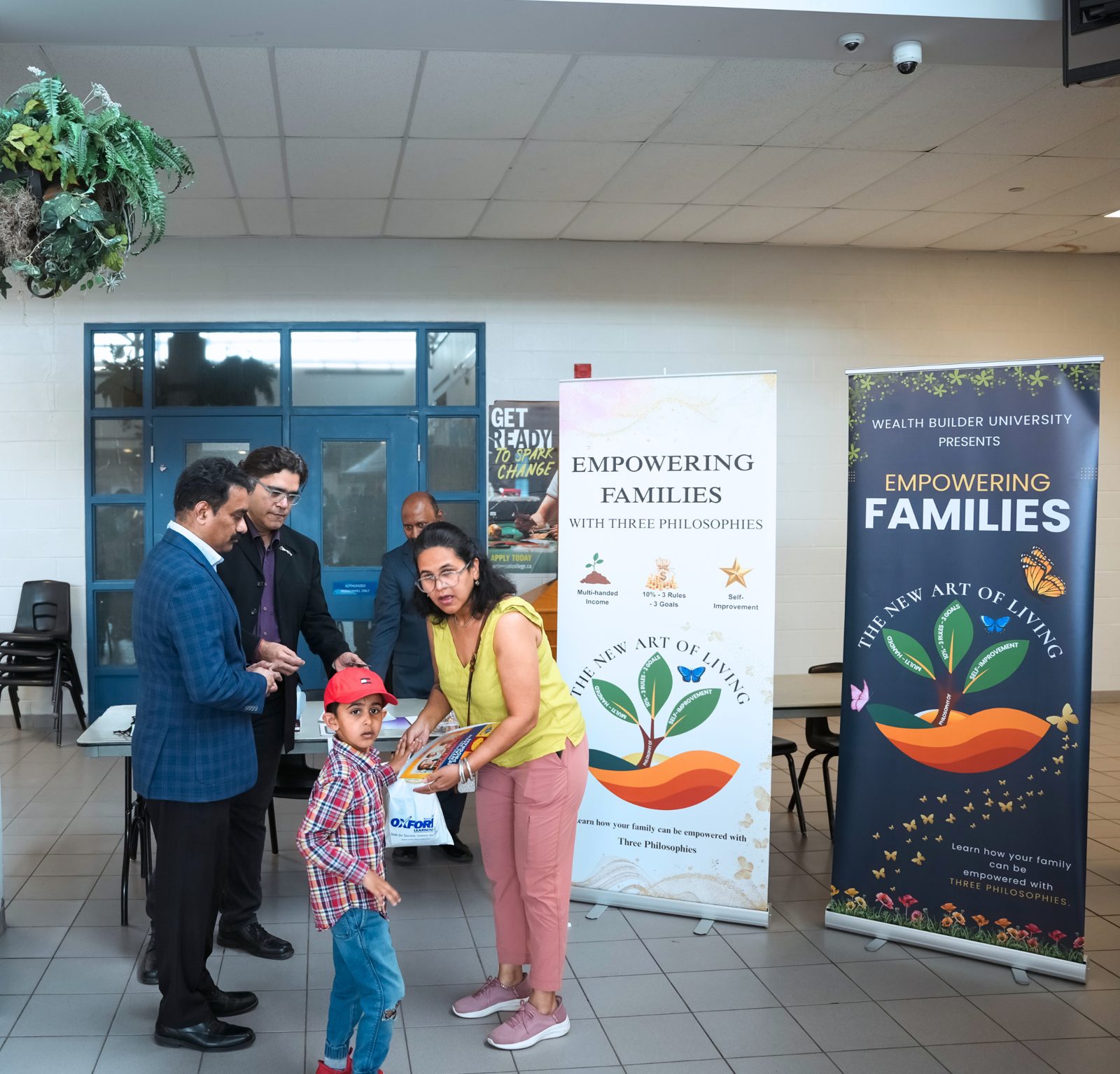 Wealth Builder University Empowering Families booth, with a woman handing a booklet to a young boy