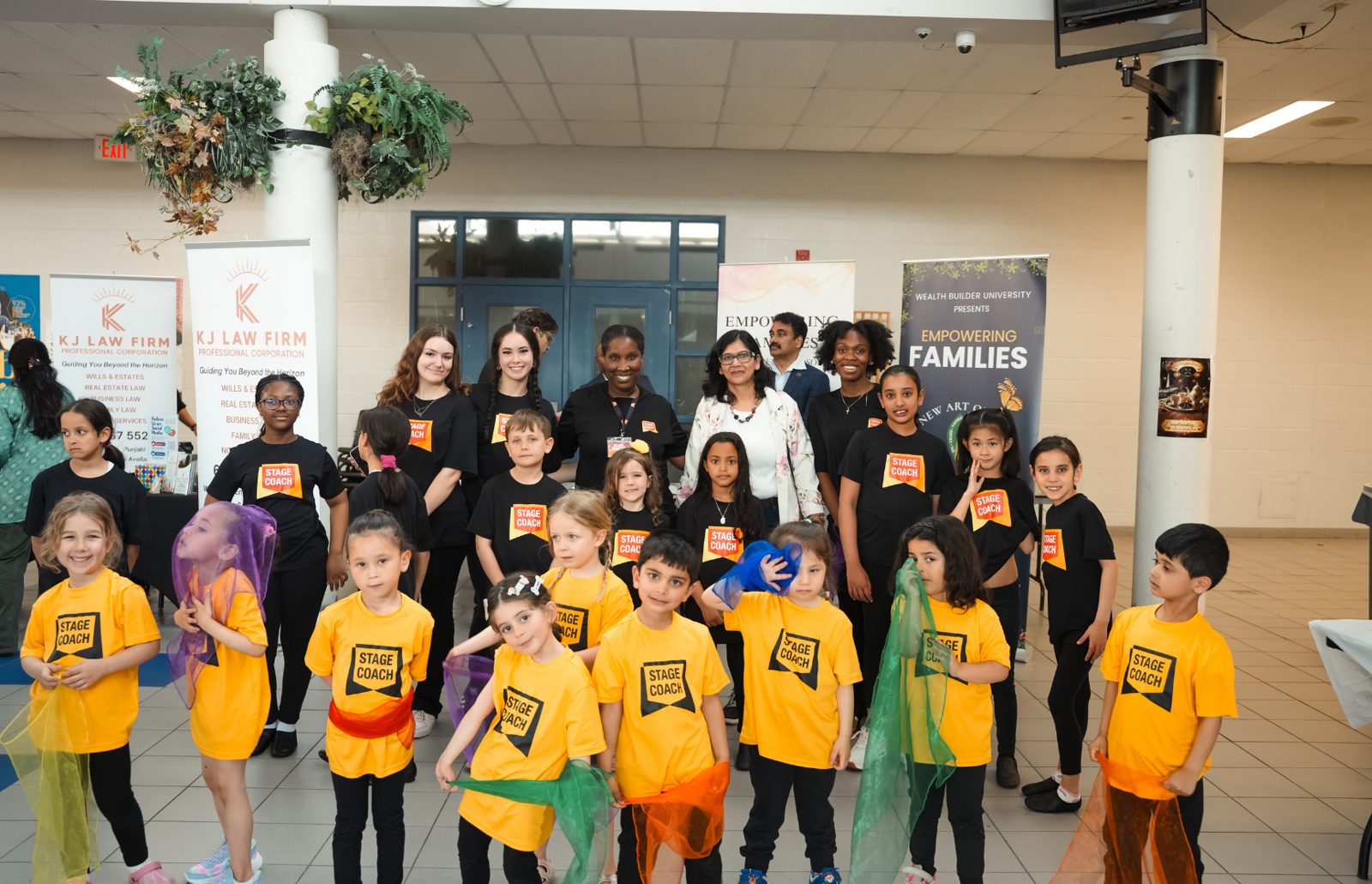 A group photo of young performers and Stage Coach teachers on the hall floor